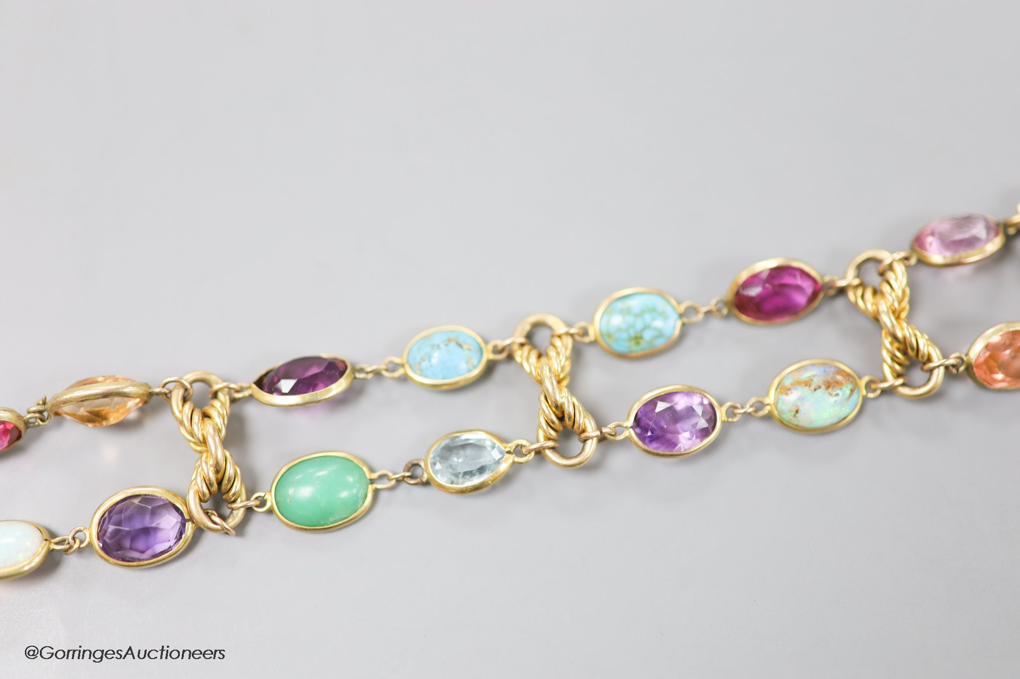An early 20th century yellow metal and multi gem set bracelet, including white opal, turquoise, amethyst etc, 17cm, gross weight 30.3 grams.